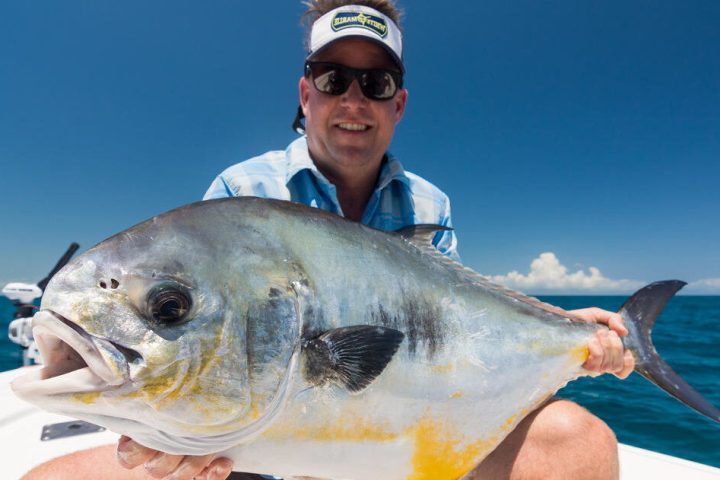 a person holding a fish swimming under water