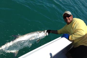 a man holding a fish in the water